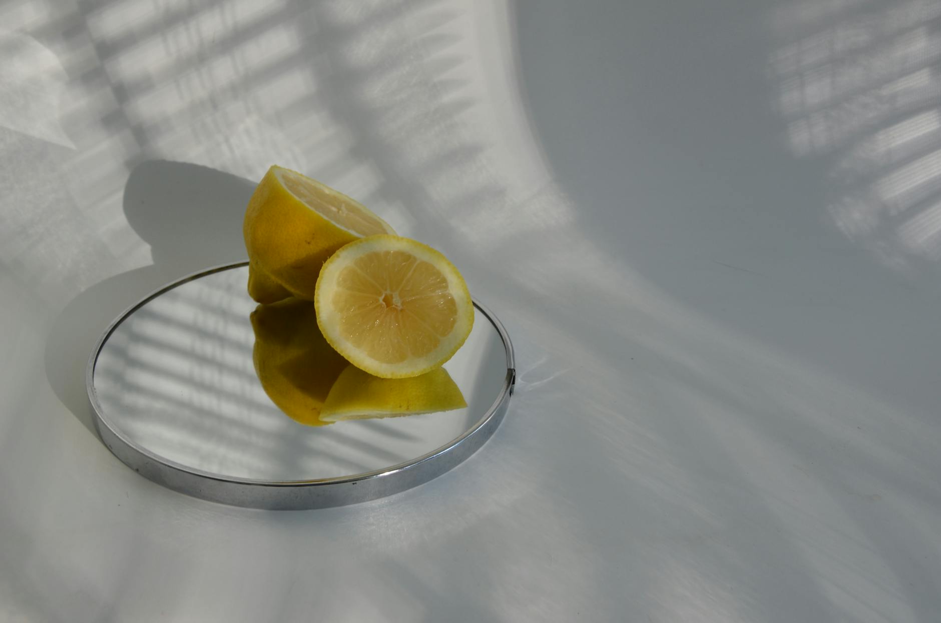 Dos manos ahuecadas sosteniendo limones frescos sobre una superficie marrón, simbolizando frescura y cuidado corporal