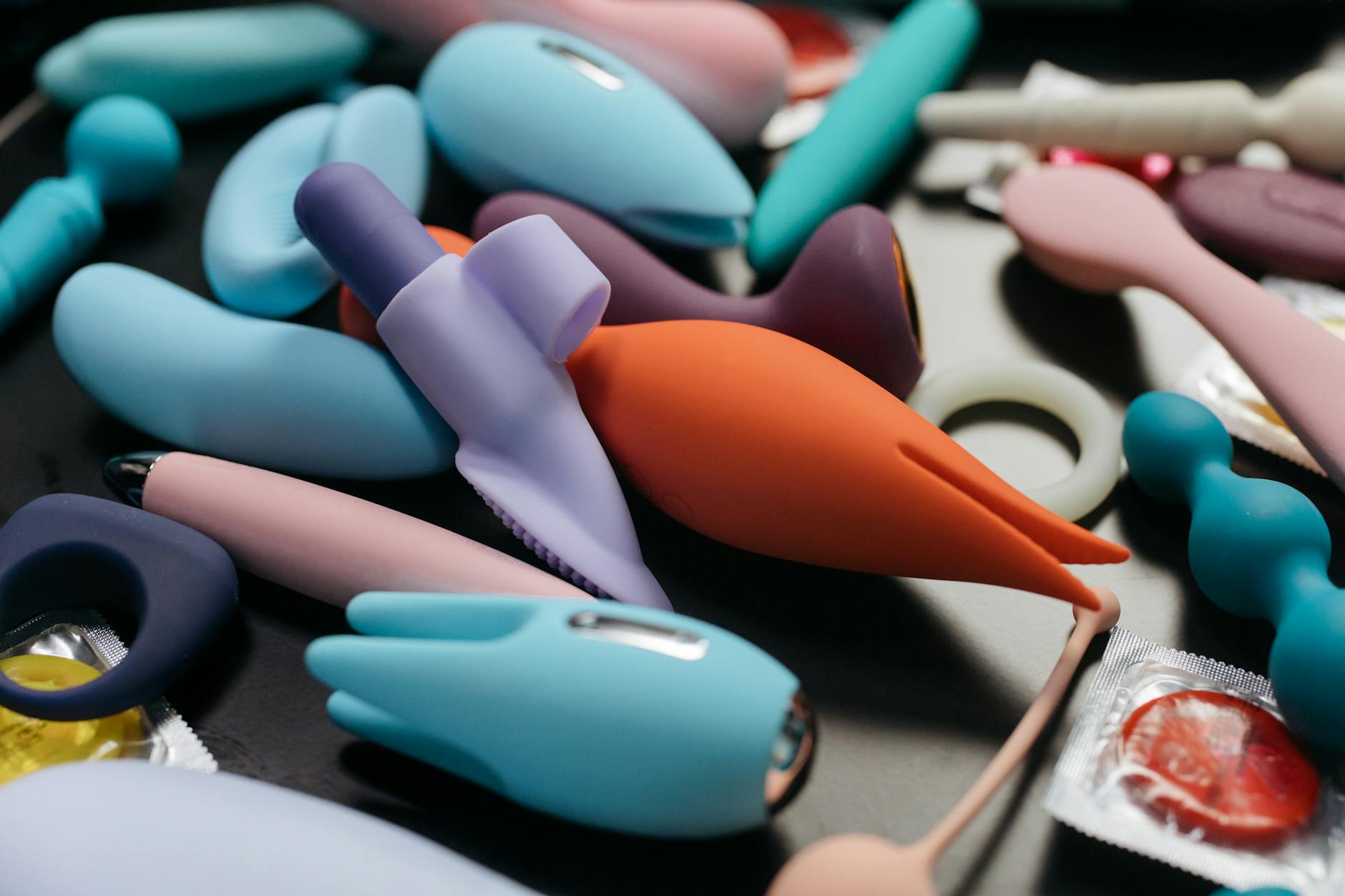 Mujer sosteniendo un vibrador rosa con libros de arte al fondo, enfatizando temas de amor propio e intimidad